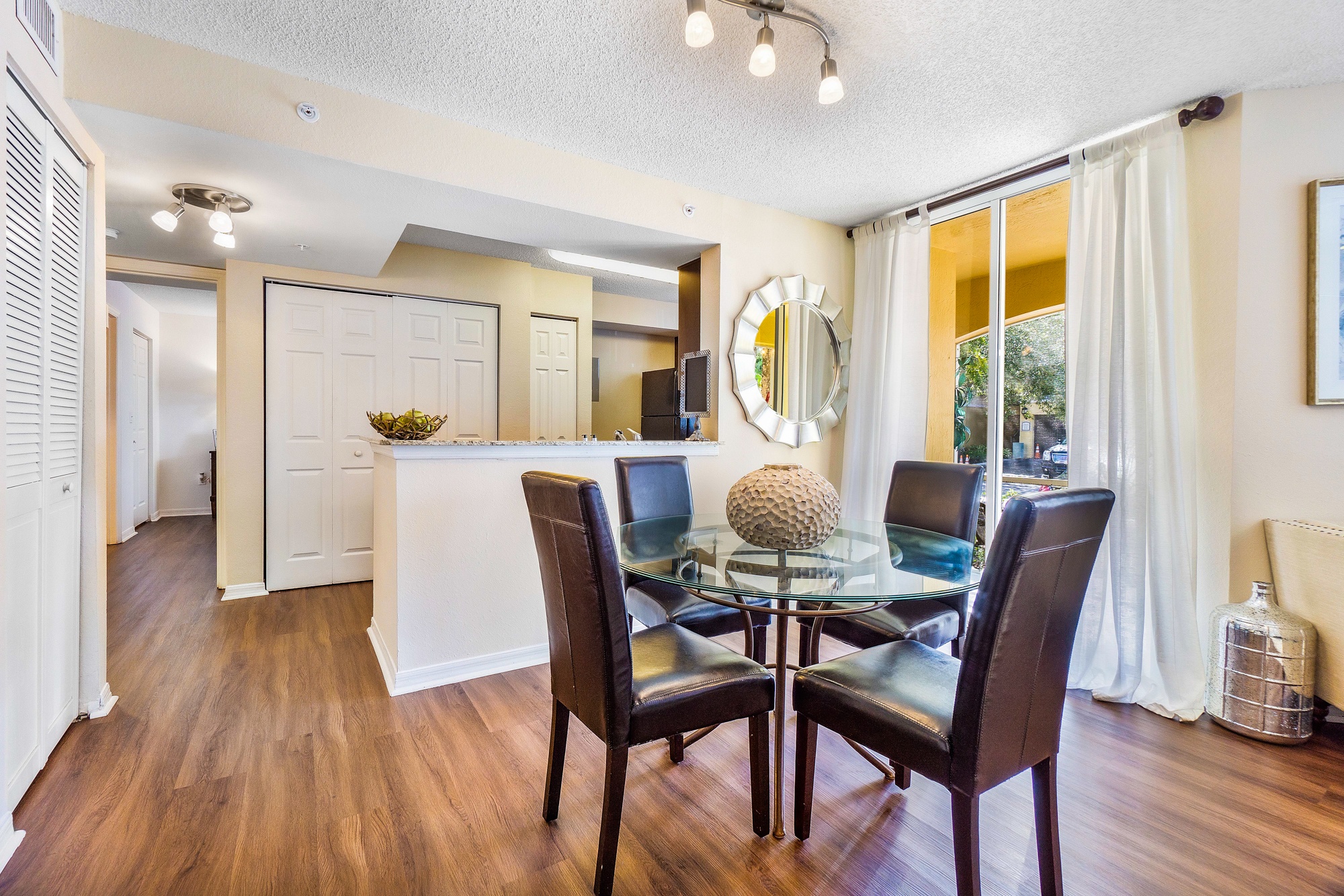 A dining room with a glass table and chairs.